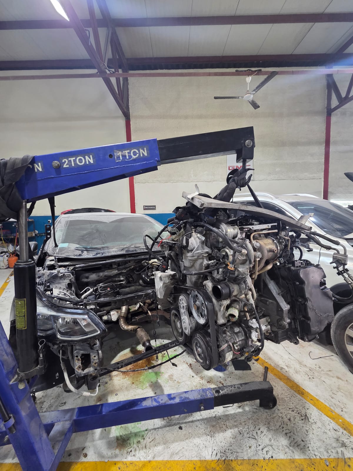 Engine removed from a car and lifted clear on an engine crane in the workshop